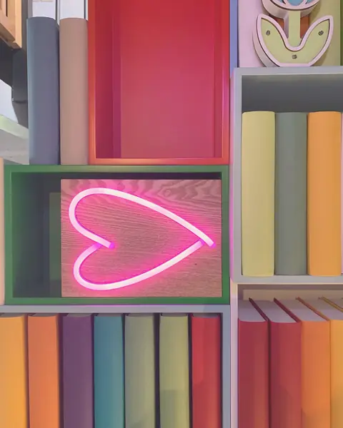 Libreria colorata con un cuore al neon rosa